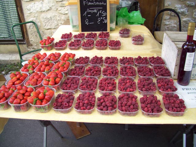 Strawberries and raspberries in punnets, for sale at Issegiac Market in France