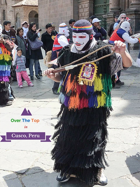 A religious festival reveller in balaclava, fringed coat and whip in Cusco, Peru