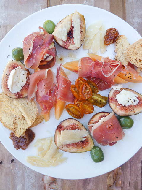 Plate of figs, cheese, prosciutto, olives and other antipasti ingredients