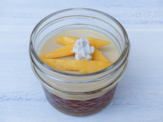 coconut tea jelly in a mini mason jat with slivers of mango on top