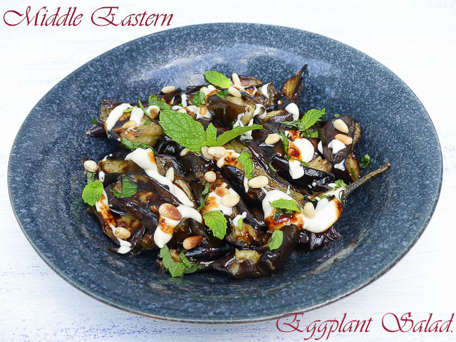 bowl of eggplant pieces with tahini sauce and mint scattered on top