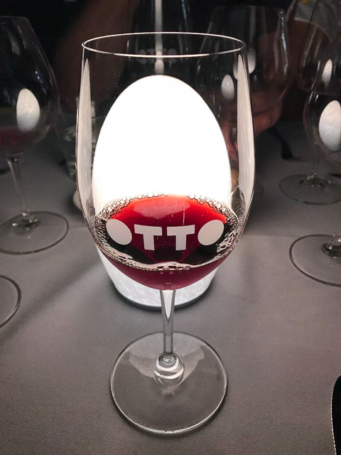 otto branded wineglass sitting in front of table lighting