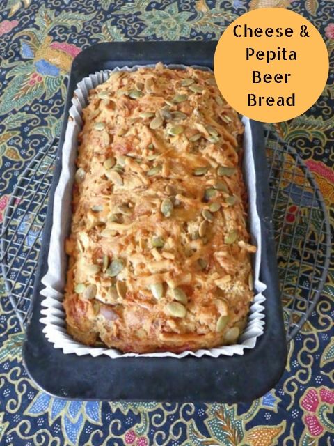 baking tin containing crusty beer bread with cheese & pepita topping