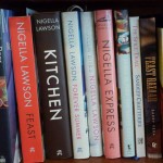 A row of cook books on a bookshelf