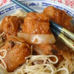 Chinese Garlic Ginger Chicken in a bowl with egg noodles and chopsticks