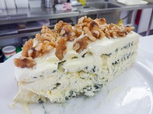 large wedge of layered blue and marscapone cheesewith walnuts on top