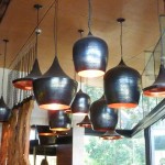 modern copper light fittings hanging in a group above a restaurant bar