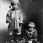 Children in traditional Chinese costume. A young boy stands and a younger child alongside him. Cooktown Queensland