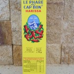 A tube of Le Phare du Cap Bon Harissa decorated withpictures of chillis and a lighthouse