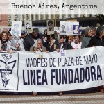 Women marching behind a protest banner in Plaza De Mayo, Buenos Aires Argentina
