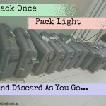 Several dozen suitcases lined up in a row against a wall