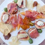 Plate of figs, cheese, prosciutto, olives and other antipasti ingredients