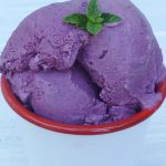 scoops of mulberry ice cream with a mint leaf garnish