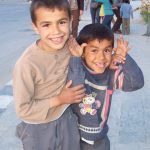 two boys clown around on the streets of palmyra, syria