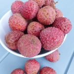 unpeeled lychees in a colander